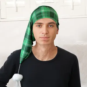 Dettaglio del berretto da notte lungo a quadri verdi con pompon bianco indossato da uomo