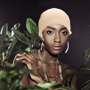 Elegant beige turban headscarf with floral design for women in a tropical setting