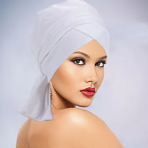 Dettaglio del turbante in velluto bianco con elegante drappeggio laterale e design avvolgente