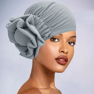 Detailed close-up of a gray fashion turban hat featuring a large 3D fabric flower design