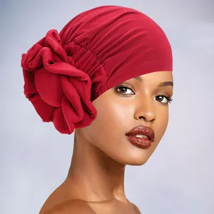 Detail of elegant red turban hat featuring a large 3D pleated sponge flower decoration