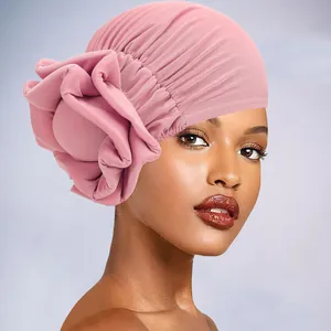 Detail of pink pleated turban with large decorative 3D flower and soft knit fabric