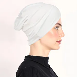 Detail of white stretch milk silk turban hat showing elegant layered pleats on women
