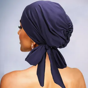 Vue détaillée d'un turban violet avec grand nœud papillon et plis soyeux à l'arrière