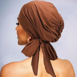 Détails du grand nœud et des plis élégants sur le turban de couleur marron café