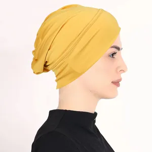 Side view of ginger yellow stretch turban cap showing soft pleats and fabric texture