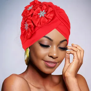Close-up of vibrant red turban with handcrafted satin flowers and sparkling rhinestones