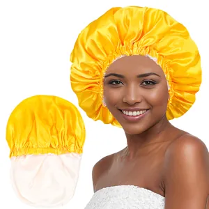 Detail of yellow satin hair bonnet showing the elastic edge and soft pink inner lining
