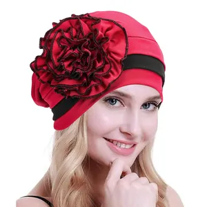 Red turban hat for women featuring large floral side decoration and black wide headband