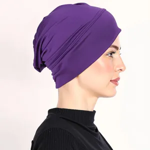 Detail of dark purple hijab cap with elastic fabric and decorative side pleats