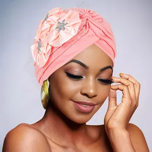Detail of pink turban cap with decorative satin flowers, rhinestones and vintage mesh veil