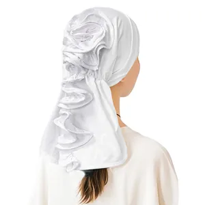 Detail of white milk silk turban showing 3D rose flower design and wavy edge back view
