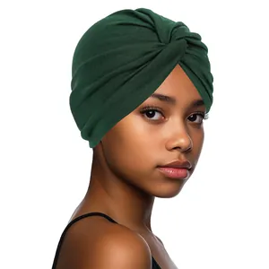 Detail of dark green turban cap showing soft elastic knitted texture and front cross knot