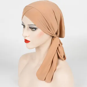 Detail showing cross-front knot and ribbed texture of an apricot stretch turban wrap