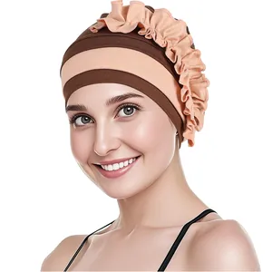 Dettaglio del turbante bicolore a righe con design a fiori a balze in maglia morbida