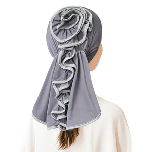 Detail view of milk silk turban with elegant flower knot and long draping fabric back
