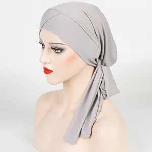 Detail showing the gray ribbed fabric and adjustable cross strap design of the turban hat