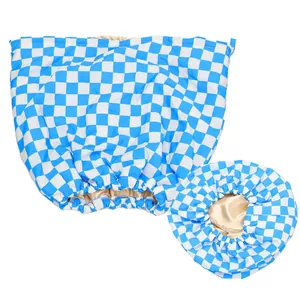 Detail of blue checkerboard waterproof shower cap showing champagne silk lining and elastic band