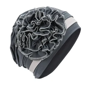 Detail of grey turban hat with side pleated flower design and elastic fabric texture