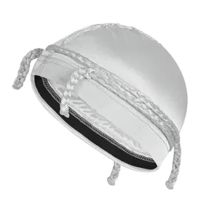 Detailed view of a white satin kippah with silk-like shine and woven braided tassels