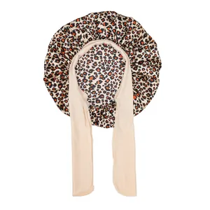 Detail of leopard print kids satin bonnet featuring wide elastic ribbon ties and silky texture