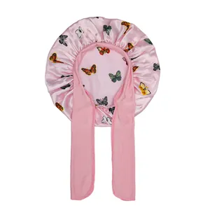 Detailed view of pink satin hair bonnet with butterfly print and wide adjustable straps