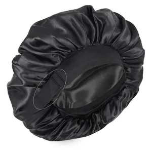 Detail einer schwarzen Schlafmütze aus Satin mit verstellbarem Gummiband und Schnalle