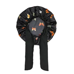 Detail of black satin sleeping bonnet with colorful butterfly prints and wide ribbons