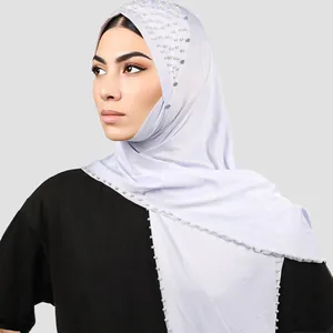 Detalle de hiyab lila con elegantes perlas blancas y brillantes adornos de pedrería
