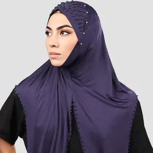 Detalle del hiyab morado oscuro con cuentas negras y pedrería plateada sobre tela