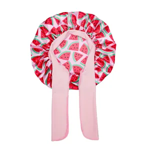 Close-up of pink satin hair bonnet with watermelon prints and adjustable long straps