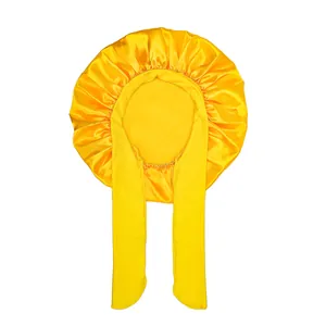 Detail of yellow satin kids sleep bonnet with wide adjustable ribbons on white background