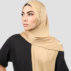 Detalle de hiyab champán con elegantes cuentas doradas y brillantes de imitación