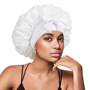 Détail du bonnet de nuit en dentelle blanche avec un grand nœud décoratif et bande élastique