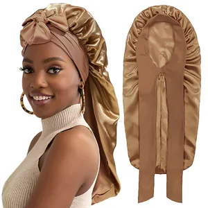 Detail of satin bonnet showing long tail design and bronze bow detail for hair care