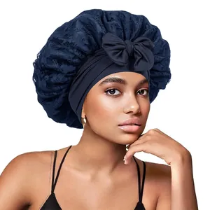 Détail d'un bonnet de nuit en satin bleu marine avec dentelle et grand ruban décoratif