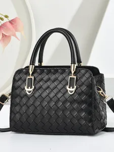 Sac bandoulière tressé noir classique avec détails dorés sur un support blanc épuré