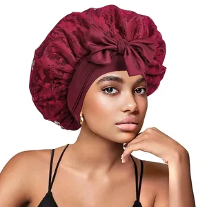 Détail d'un bonnet de nuit en dentelle bordeaux avec un élégant nœud sur un mannequin
