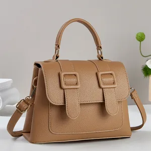 Detailed macro of light brown pebble leather texture and gold buckle hardware