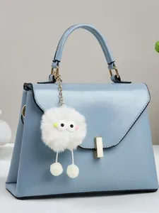 Elegante hellblaue Trapez-Umhängetasche mit Plüsch-Anhänger und Goldbeschlägen