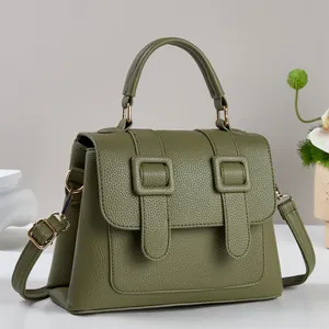 Macro shot of olive green pebbled leather bag texture with pale gold hardware