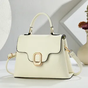 Dettaglio della borsa elegante in pelle color crema con fibbia in metallo dorato