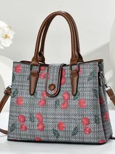 Elegant grey floral handbag with red cherry print and brown leather handles