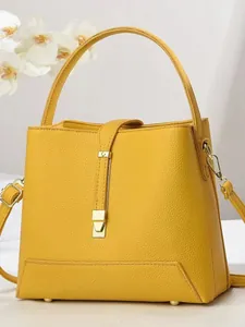 Minimalist bright yellow lychee pattern bucket bag with metal buckle and top handle