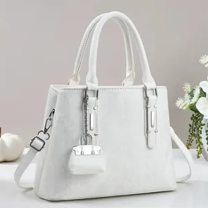 Close-up of white tote bag featuring vertical striped texture and matching mini pouch charm
