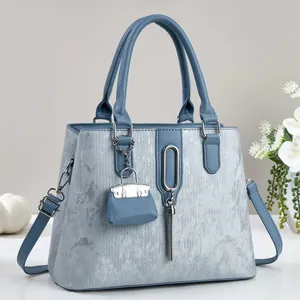 Detail van lichtblauwe getextureerde shopper met zilveren kwastje en mini-bedeltje