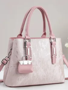 Elegant pale pink tote bag with metallic texture, dual handles and adjustable shoulder strap