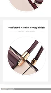 Detail of burgundy and cream leather handbag with reinforced handle and gold hardware