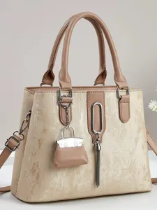 Elegante gouden shopper met metalen verticale strepen en een kwastje als hanger