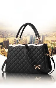 Détail du sac à main en cuir matelassé noir avec nœud doré et bordure ondulée chic